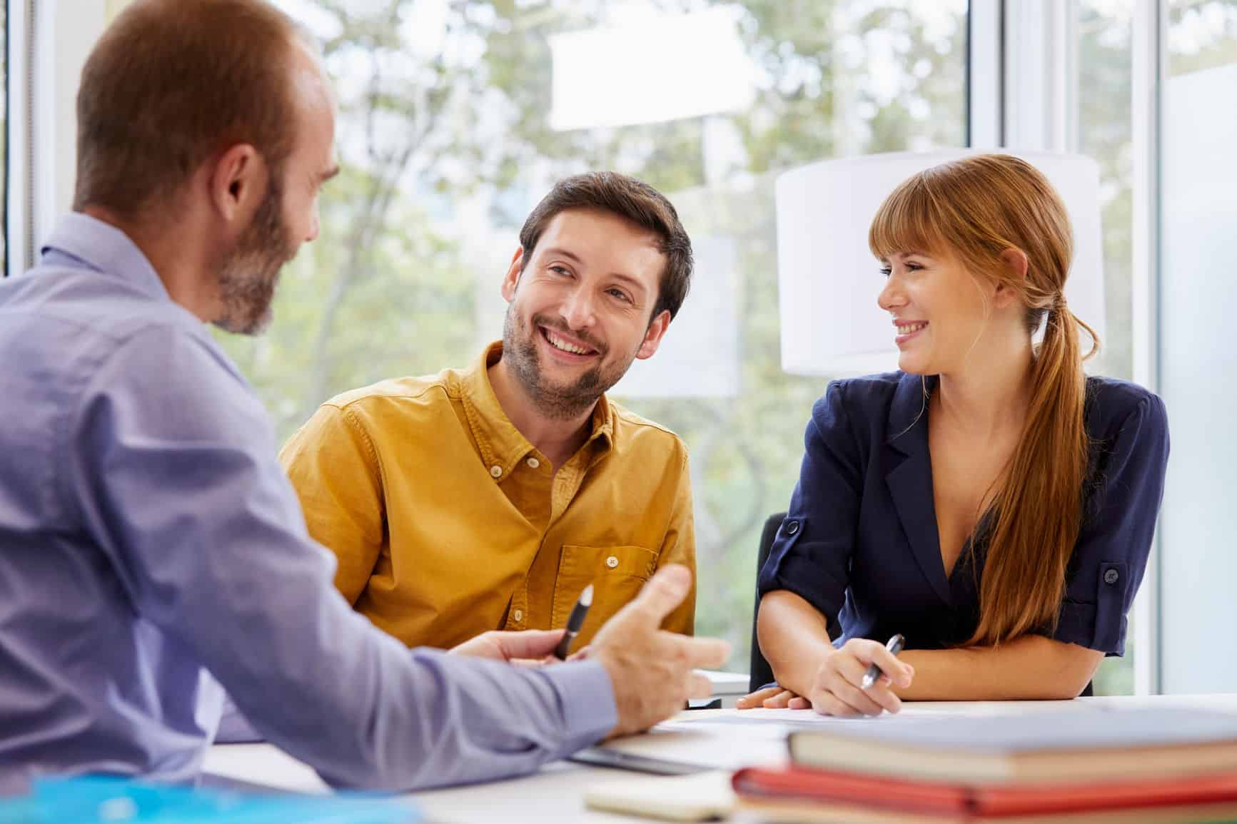 Couple Listening To Advisor Discussing In Office