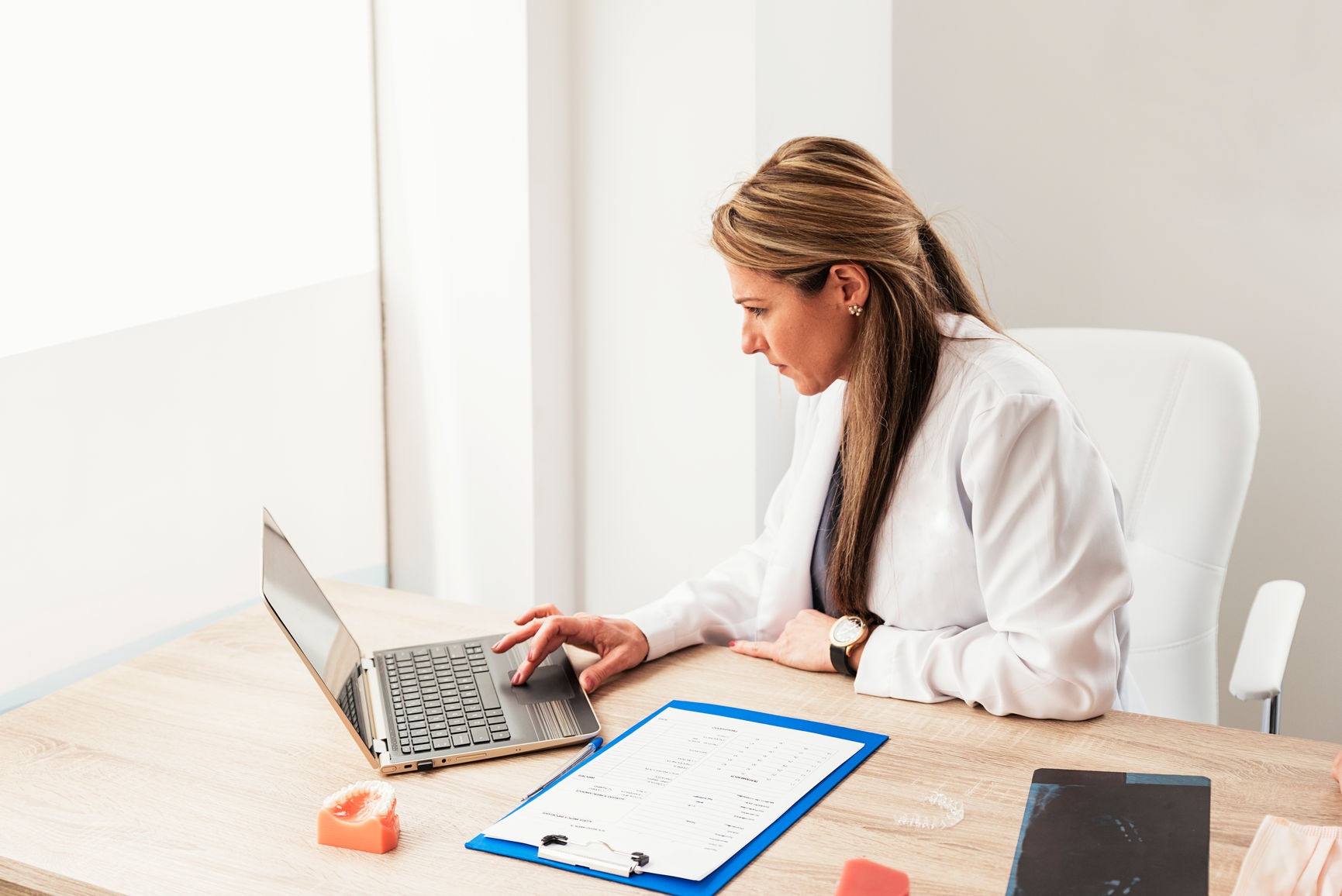 Doctor Working With Her Laptop In Dental Clinic.